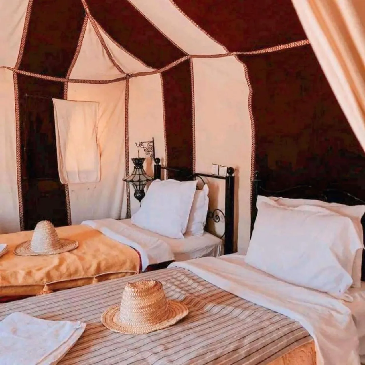Sahara Luxe Camp – Merzouga, Morocco hotel – two beds in a room with hats on top of them at Sahara Luxe Camp in Merzouga