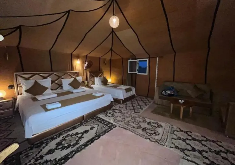 Sahara Soul Luxury Camp in Merzouga deluxe tent suite with double bed, twin bed, and cozy seating area.