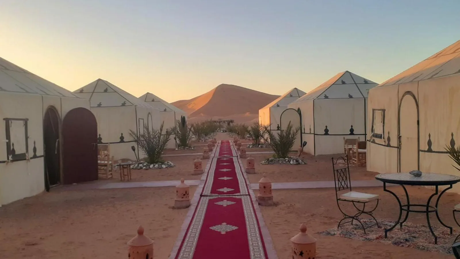 Exterior view of Sahara Tours luxury camp in Merzouga at sunrise