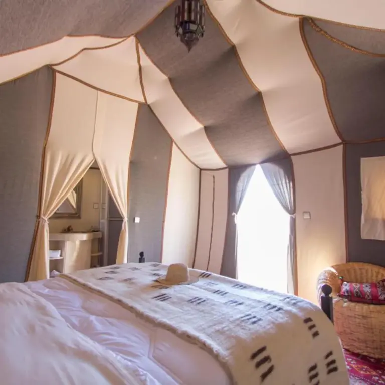 Elegant tent bedroom inside Sahara Tours luxury camp in Merzouga