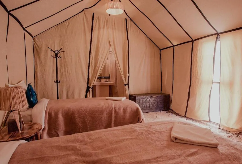 Vue intérieure d'une chambre de tente au Sandrock Luxury Camp à Merzouga