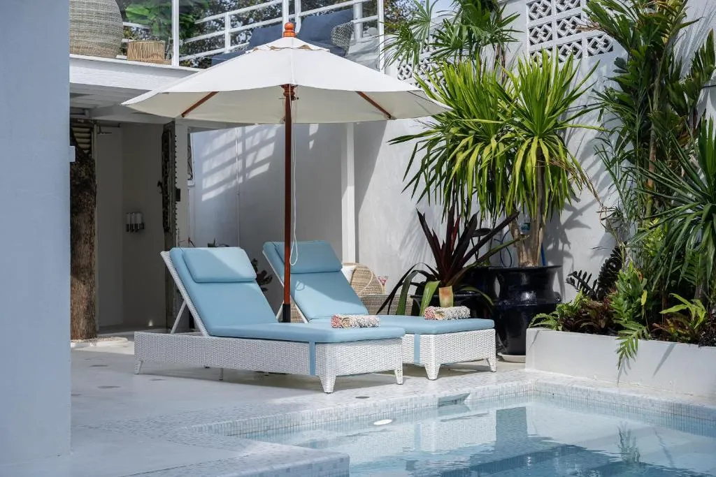 Sillas de lounge junto a la piscina en Santitham Pool Villa en Chiang Mai