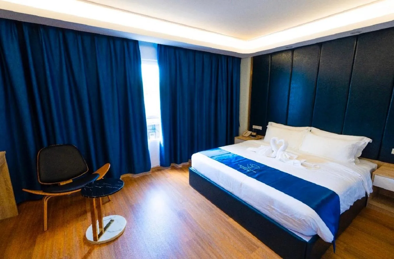 Stylish bedroom with bed and lounge chair at Sapphire Hotel Silom Bangkok Bangkok