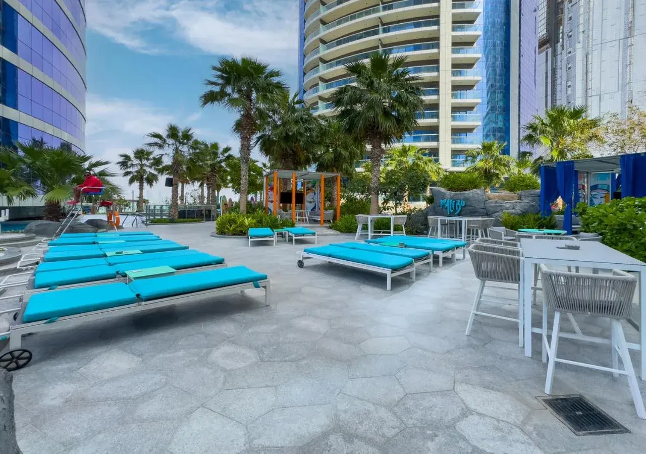 Tumbonas junto a la piscina en Savis Homes - Damac Paramount Tower A 1BR Ultimate Luxury and Glam Escape en Dubái