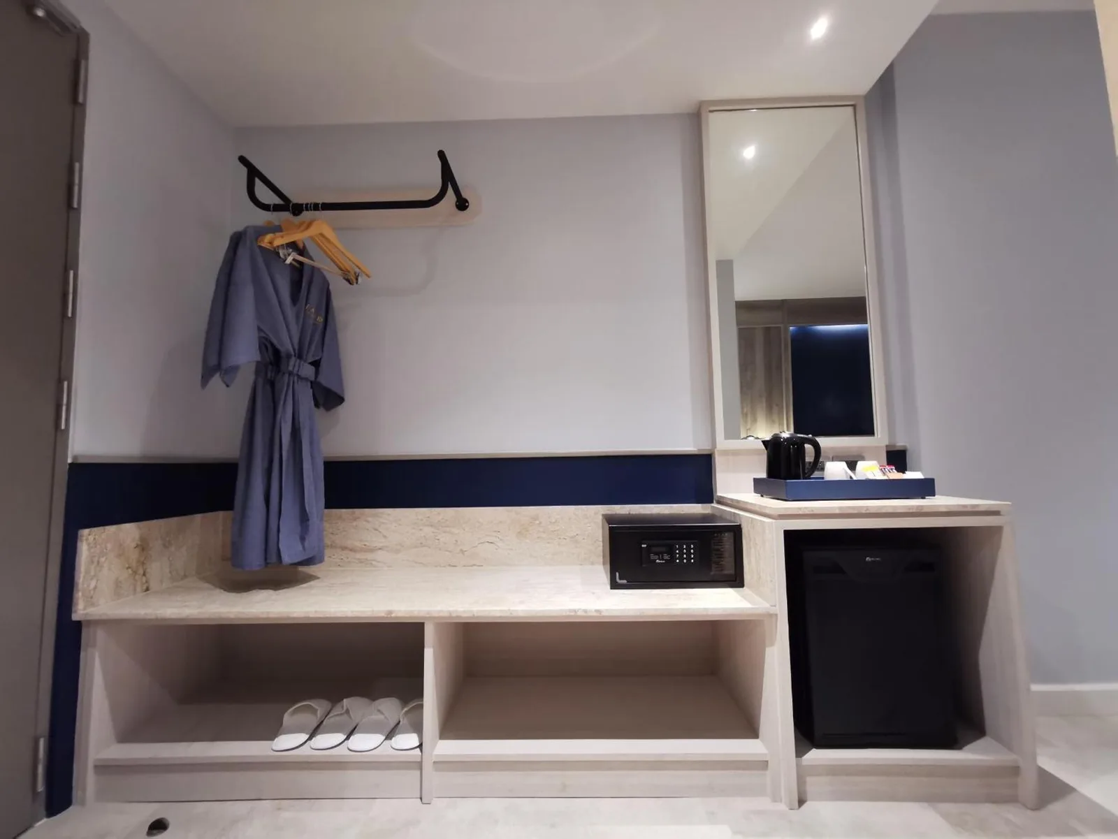 Armoire et espace équipements à l’intérieur du Seabed Grand Hotel Phuket à Phuket avec peignoirs, étagères de rangement et miroir.