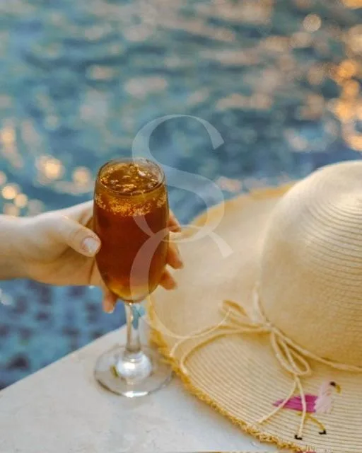 Hand holding a drink by Seascape Villa pool