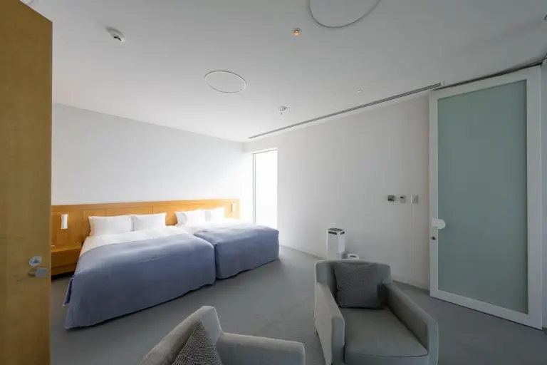 SETOUCHI RETREAT AONAGI by Onko Chishin – Matsuyama, Japón hotel – un dormitorio con una cama grande y una silla en SETOUCHI RETREAT AONAGI by Onko Chishin en Matsuyama