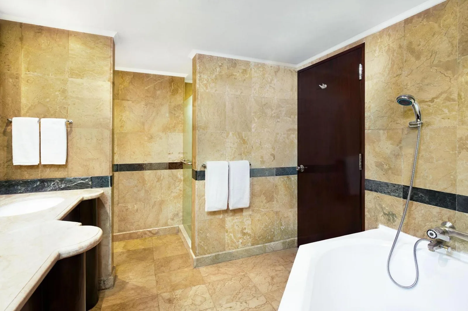 Marble bathroom at Sheraton Senggigi Beach Resort in Mataram with bathtub, shower, and vanity area.