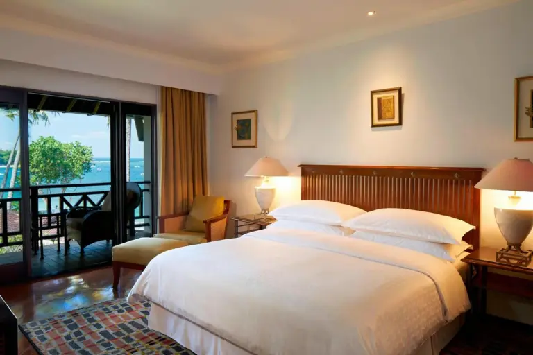 Suite living and dining area at Sheraton Senggigi Beach Resort in Mataram with sofa, dining table, and sea view.