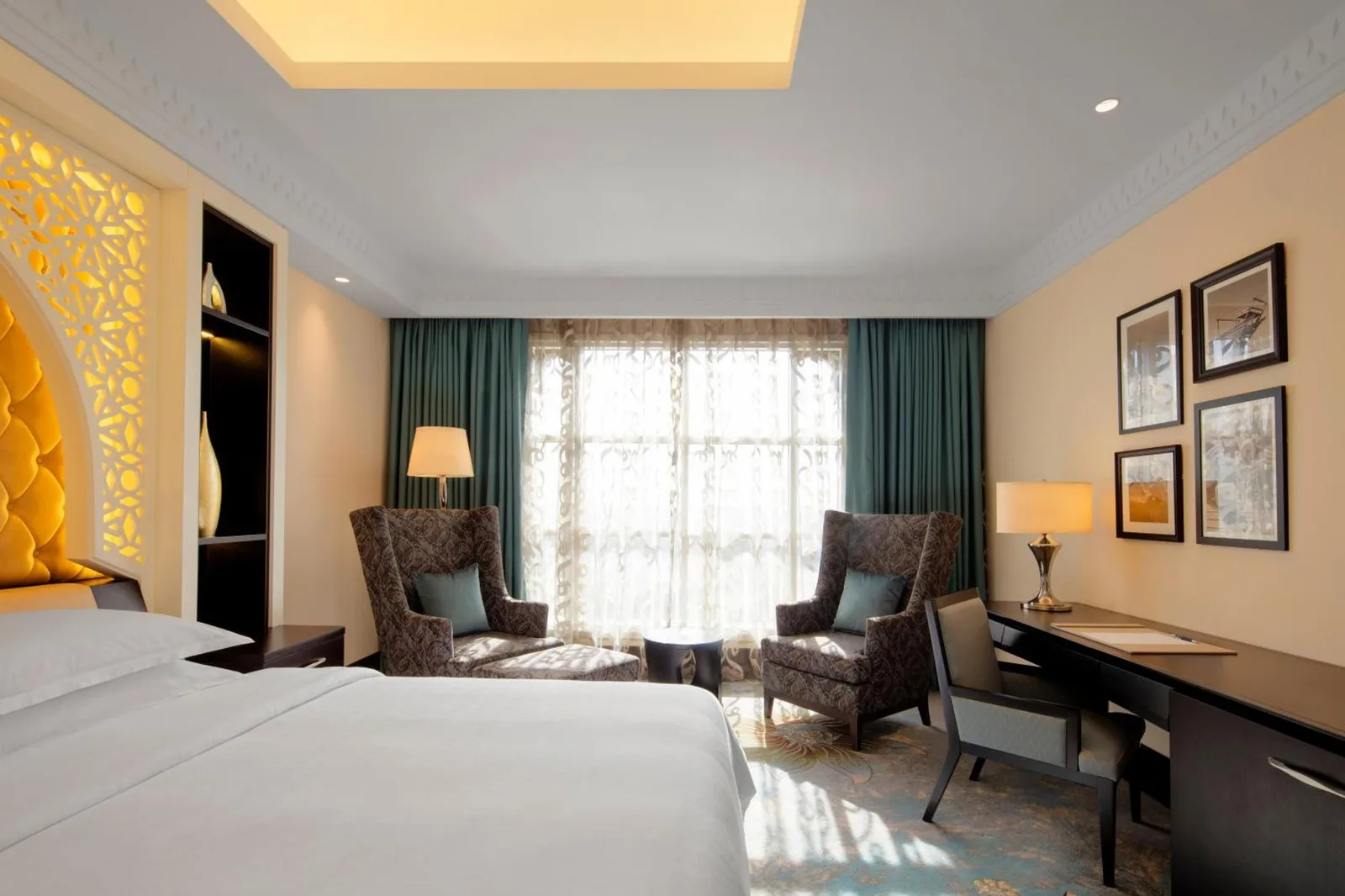 Elegant guest room at Sheraton Sharjah Beach Resort and Spa in Sharjah with twin beds, seating area, and desk