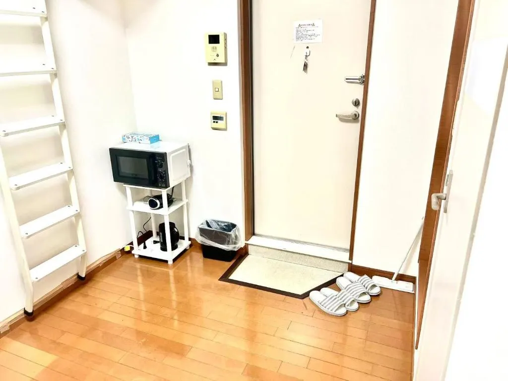 Entry area of Shinjuku Bee house with microwave and slippers