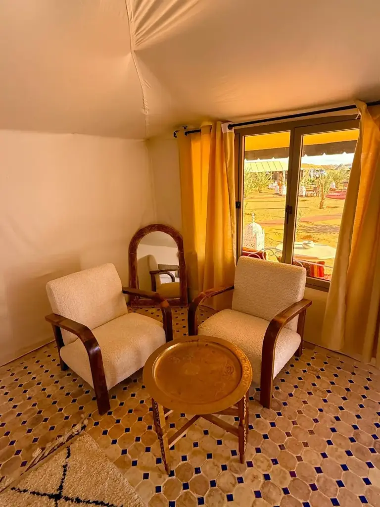 Sitzbereich im Inneren eines Luxuszelt im Sinbad Merzouga Camp in Merzouga mit Sesseln und Blick aus dem Fenster