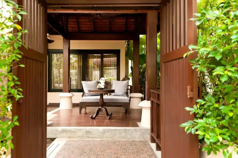 Entrada abierta de la villa en Siripanna Villa Resort & Spa Chiang Mai -SHA Extra Plus con un porche privado con asientos.