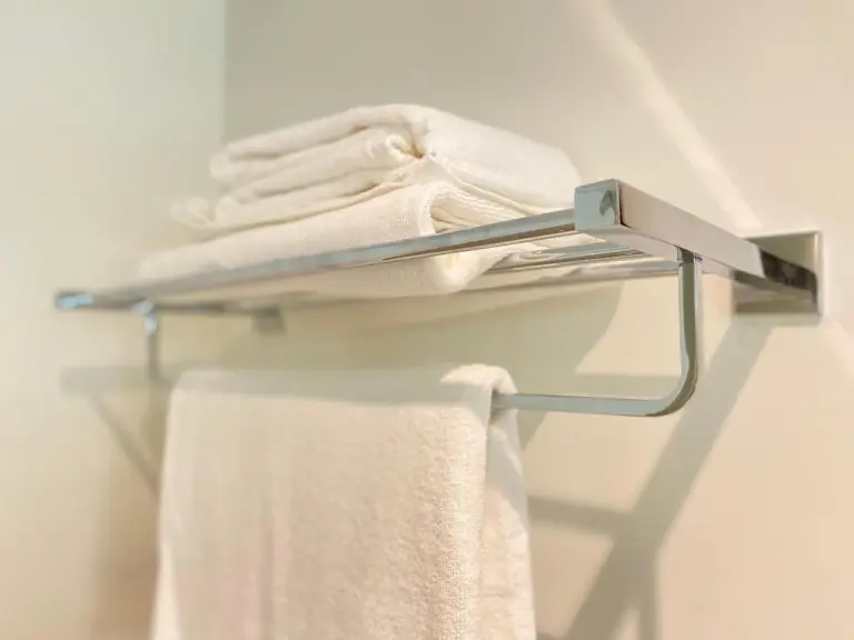 Serviettes propres pliées sur un porte-serviettes dans une salle de bains de Sitara Hotel Apartment à Dubaï