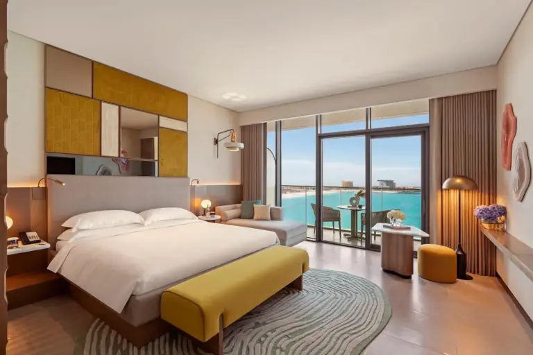 SO Ras Al Khaimah Hotel & Resort-Ultra All Inclusive – hôtel à Ras Al Khaimah, Émirats arabes unis – une chambre d’hôtel avec un lit et une grande fenêtre au SO Ras Al Khaimah Hotel & Resort-Ultra All Inclusive à Ras al Khaimah