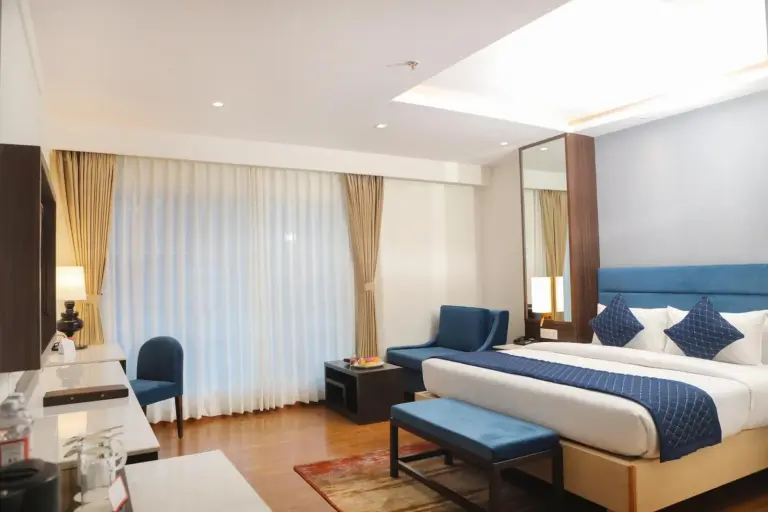 Deluxe-Gästezimmer im Soaltee Westend Itahari in Dharan mit King-Size-Bett, Sofa und hellem Tageslicht am Fenster
