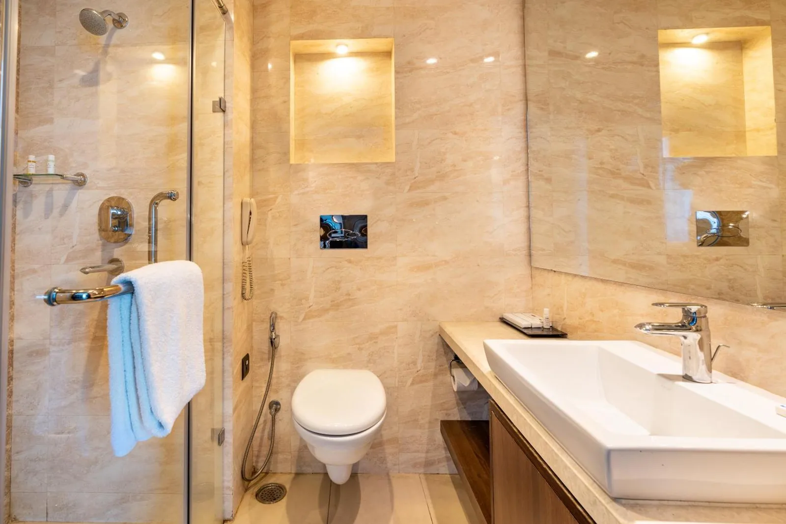 Interior de baño moderno en Soaltee Westend Premier Nepalgunj con lavabo, espejo y inodoro