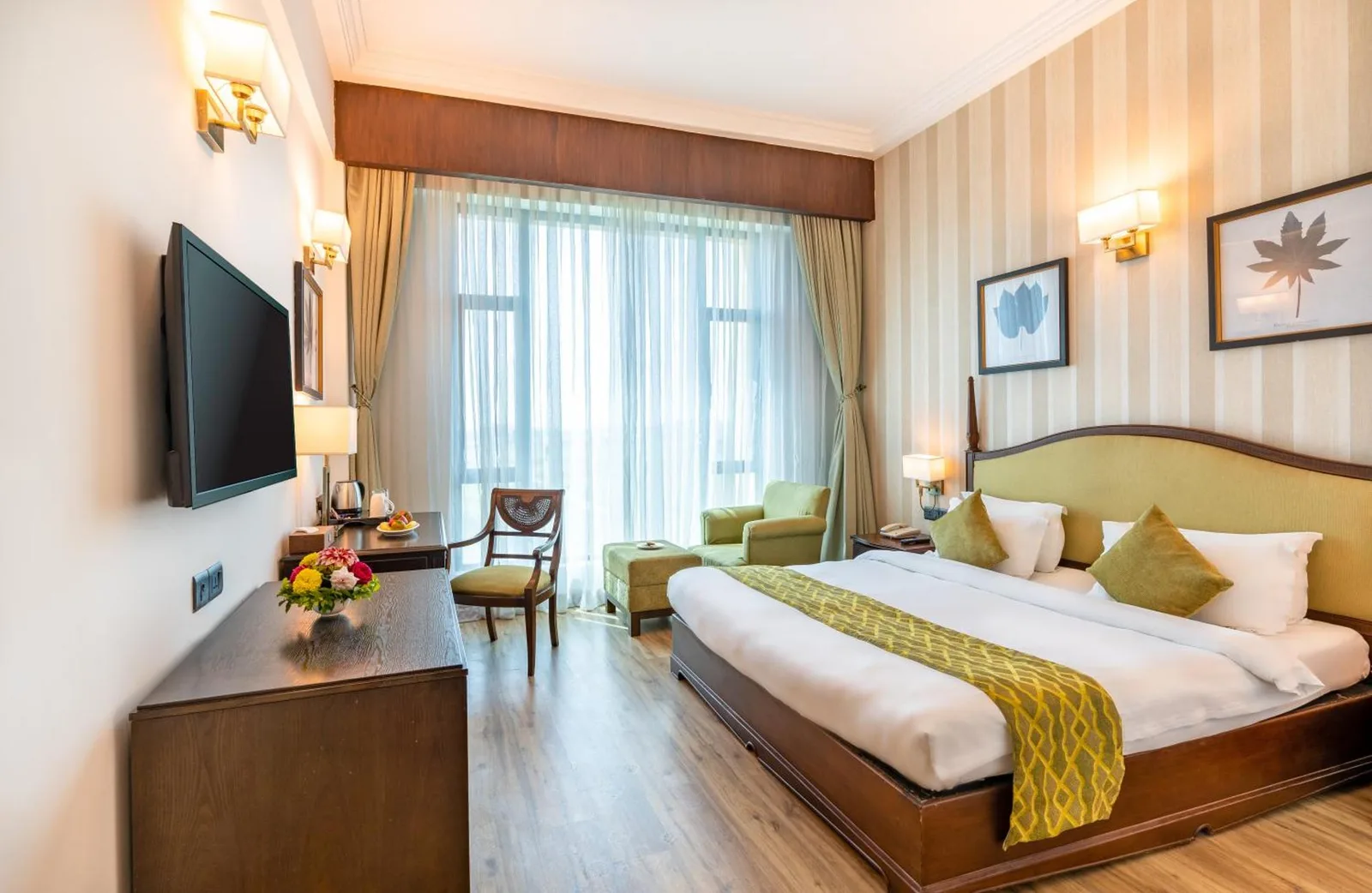 Elegante habitación king en Soaltee Westend Premier Nepalgunj con cama, escritorio y sillón