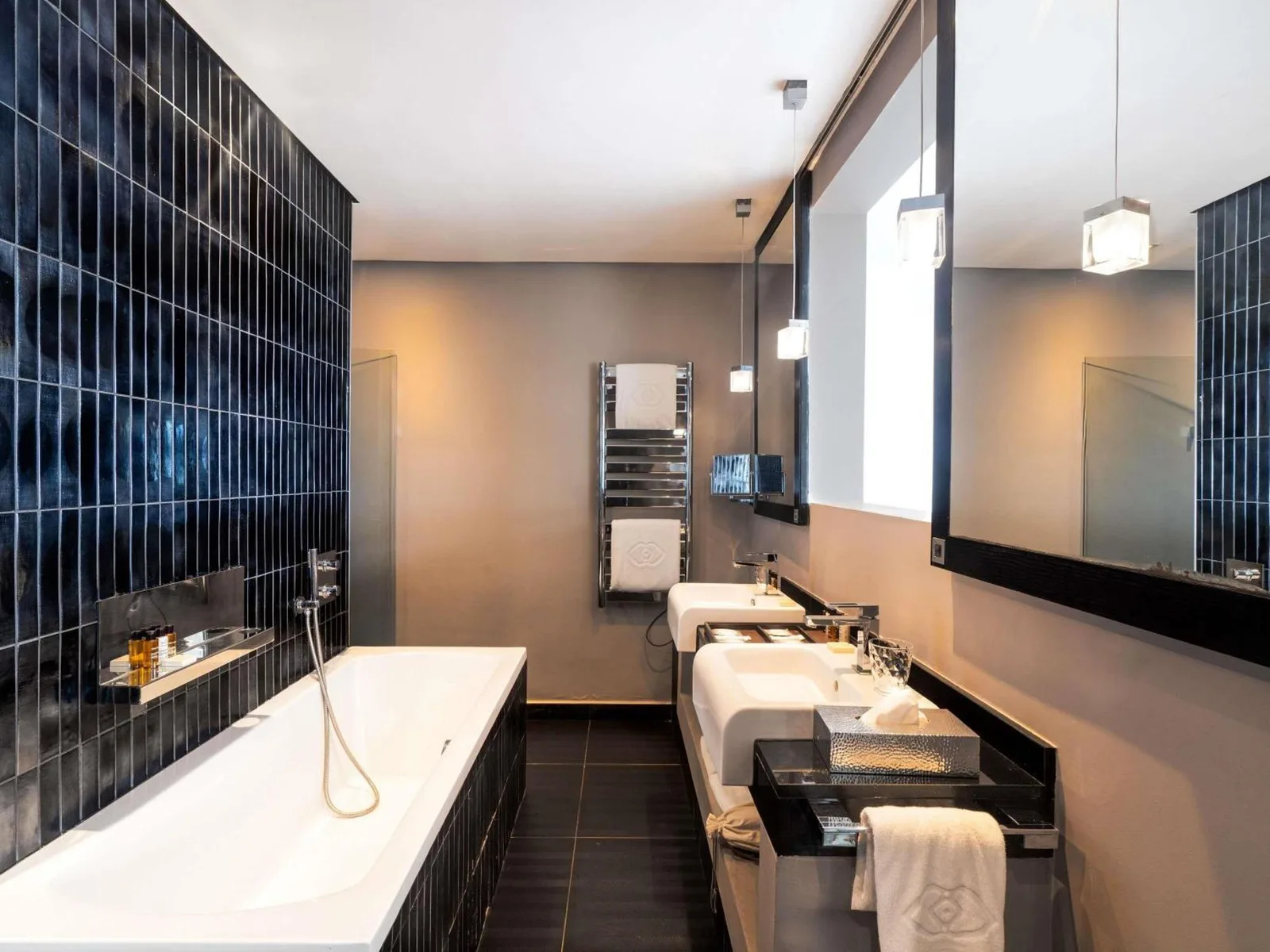 a bathroom with two sinks and a tub and a mirror at Sofitel Casablanca Tour Blanche in Casablanca