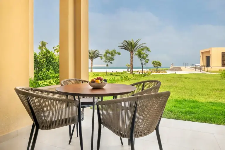 Sofitel Ras Al Khaimah Al Hamra Beach Resort – hôtel à Ras Al Khaimah, Émirats arabes unis – une table et des chaises avec vue sur l'océan au Sofitel Ras Al Khaimah Al Hamra Beach Resort à Ras Al Khaimah