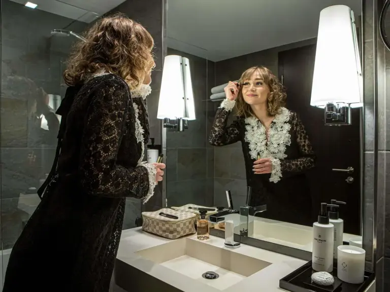 Modelo aplicándose maquillaje en el baño de Sofitel Strasbourg Grande Ile