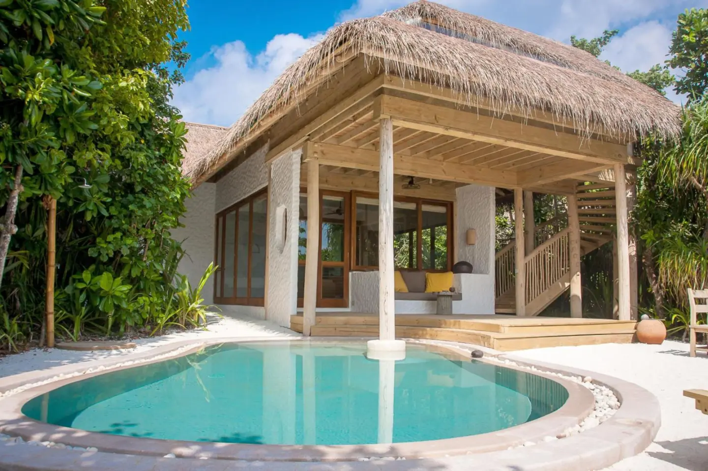 Beautiful poolside view of a Soneva Fushi villa surrounded by nature.