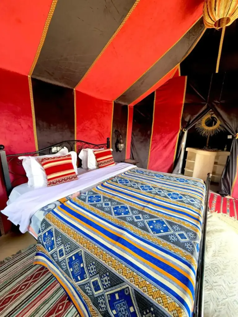 Doppelbett-Zeltzimmer im Stargazing Merzouga Camp mit roter und schwarzer Drapierung in Merzouga