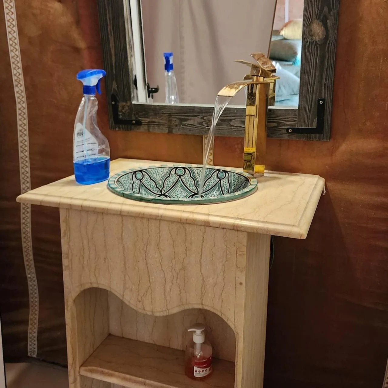 Starlight Erg Luxury Camp – Hotel in Merzouga, Marokko – ein Waschbecken im Badezimmer mit einer Seifenflasche und einem Spiegel im Starlight Erg Luxury Camp in Merzouga