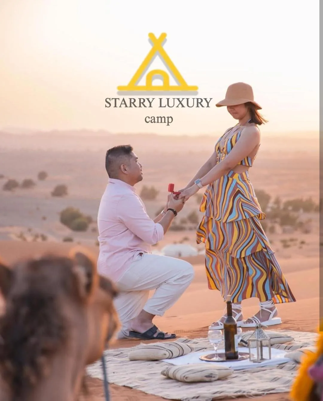 Montaje romántico para una propuesta en STARRY LUXURY CAMP en Merzouga con una pareja sobre una duna del desierto al atardecer.