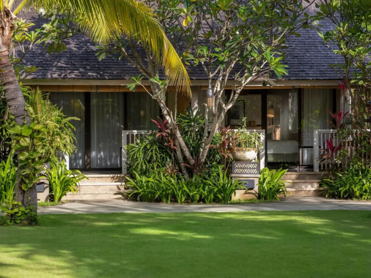 Bungalow-Außenbereich, umgeben von üppiger Vegetation im Sudamala Resort, Komodo.