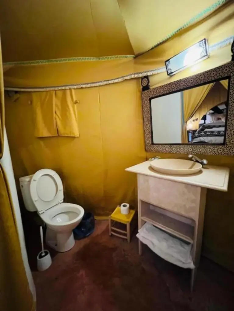 Salle de bains privative au Sunbright Luxury Camp à Merzouga avec toilettes, lavabo et miroir