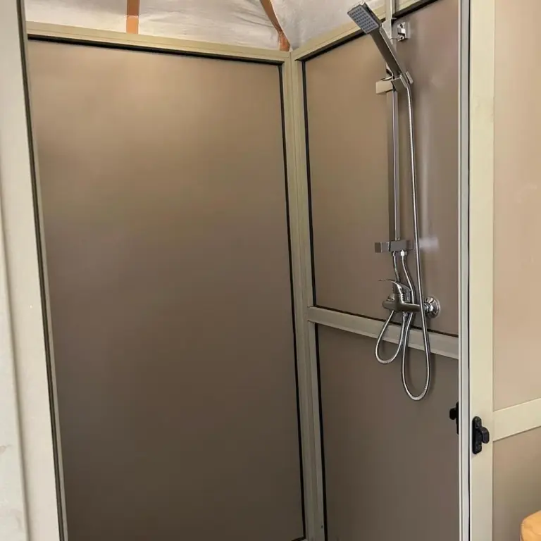Espace douche privatif au Sunbright Luxury Camp à Merzouga avec panneaux beige modernes