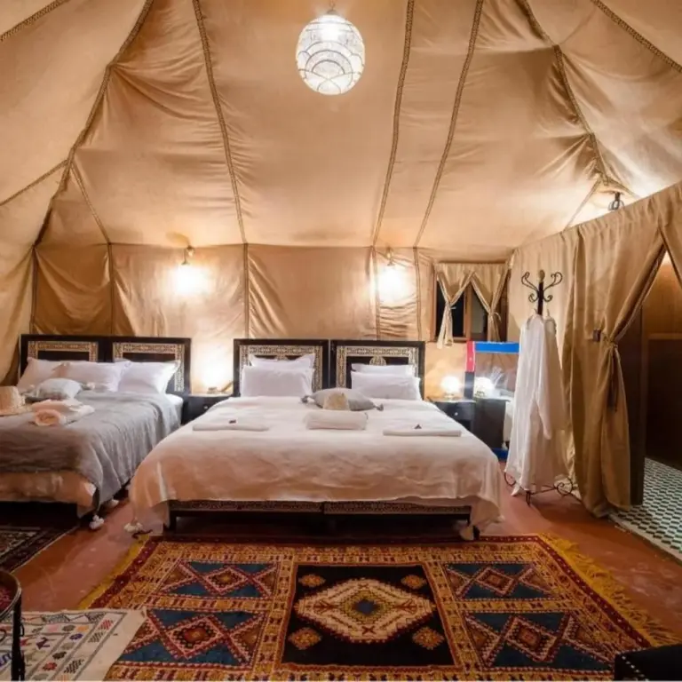Chambre en tente de luxe au Sunbright Luxury Camp à Merzouga avec grand lit et éclairage élégant