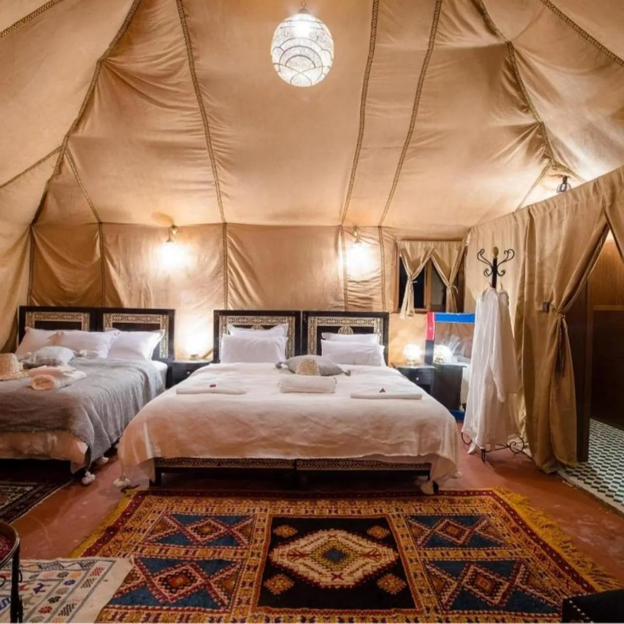 Chambre en tente de luxe au Sunbright Luxury Camp à Merzouga avec grand lit et éclairage élégant