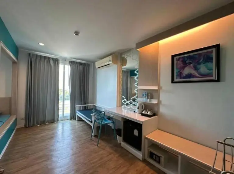 Habitación amplia para huéspedes en Sunday Beachfront View Jomtien Pattaya con escritorio de trabajo, zona de estar y balcón