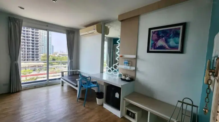 Dormitorio de planta abierta en Sunday Beachfront View Jomtien Pattaya con pared azul de acento y zona de estar
