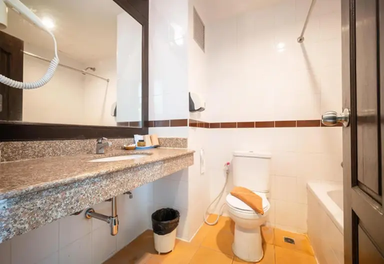 Baño en Sunday JA Plus Hotel en Pattaya con lavabo, inodoro, bañera y espejo