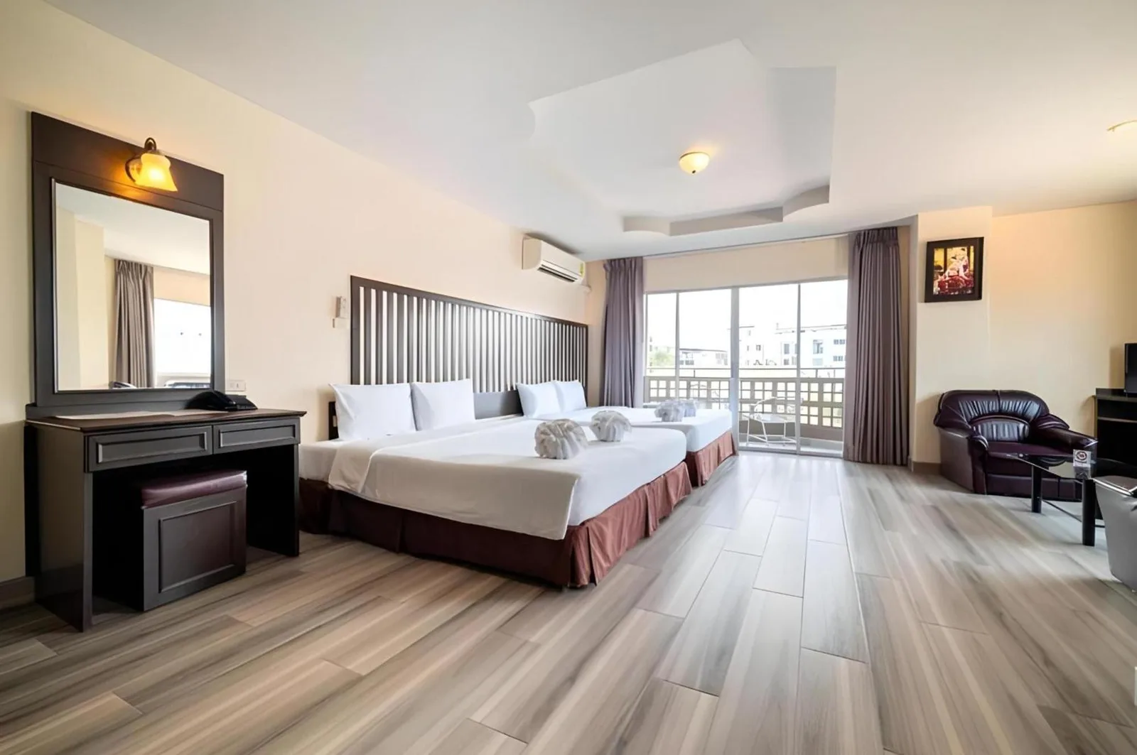 Amplio dormitorio twin en Sunday JA Plus Hotel en Pattaya con escritorio de tocador y puertas al balcón