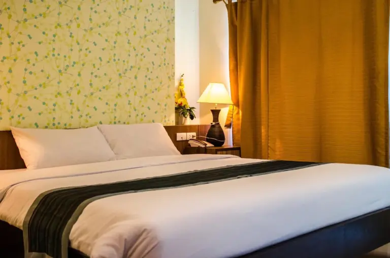 Primer plano de una cama doble en una habitación de huéspedes de Sunday Platinum Suites Bangkok