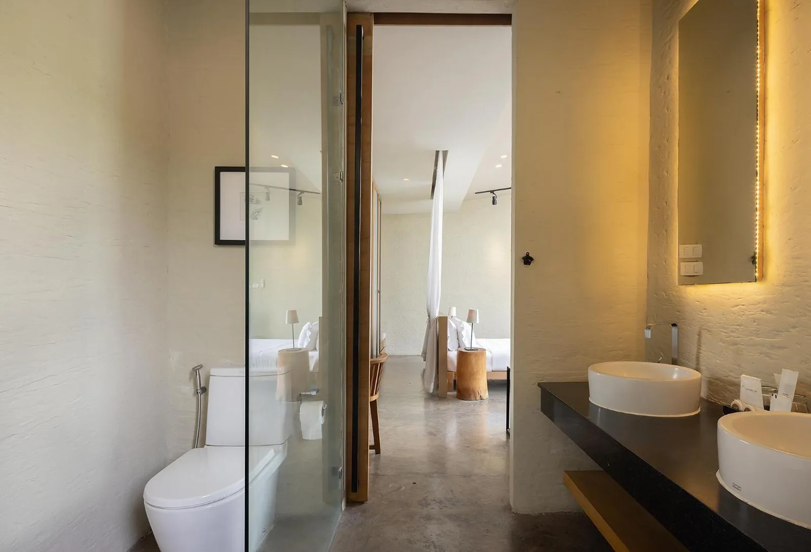 Bathroom vanity and toilet at Sunday Sea Two Pool Villa Pattaya with modern fixtures and glass partition