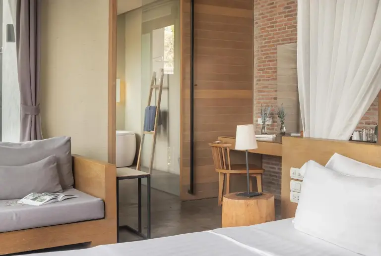 Bedroom detail at Sunday Sea Two Pool Villa Pattaya showing the sofa, desk, and bathroom entrance