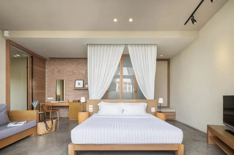 Bedroom interior at Sunday Sea Two Pool Villa Pattaya with a king bed, seating area, and work desk