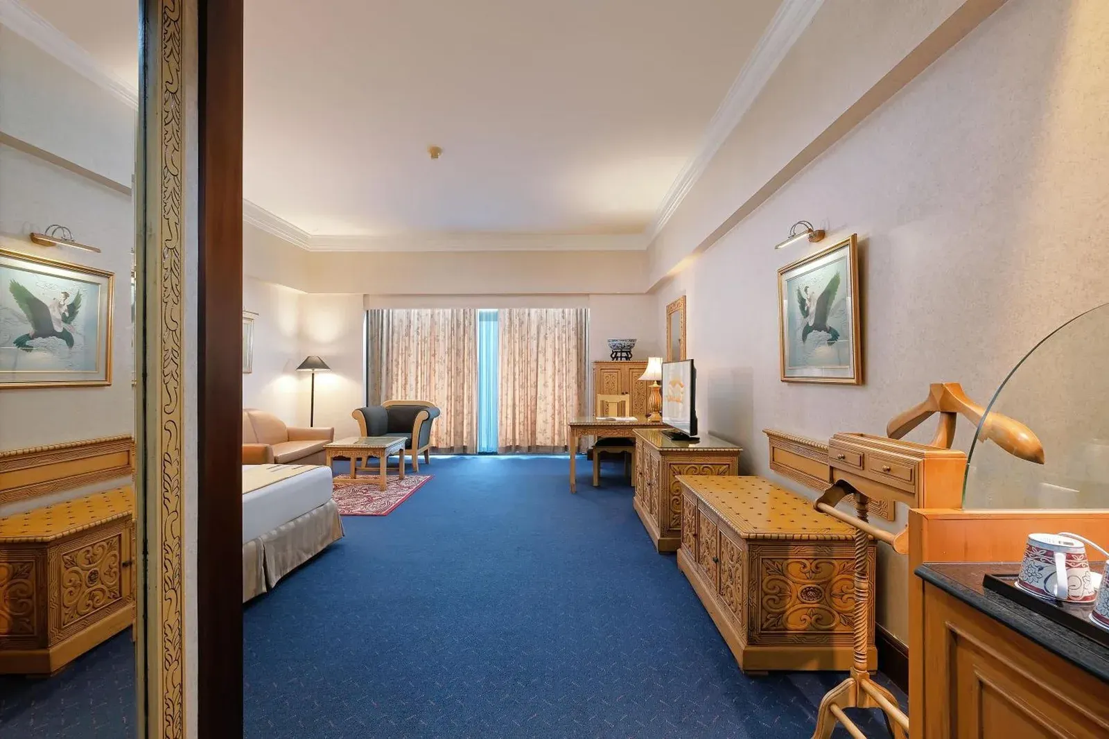 Elegant suite at Sunlake Waterfront Resort & Convention Jakarta with dining area, seating, and king bed