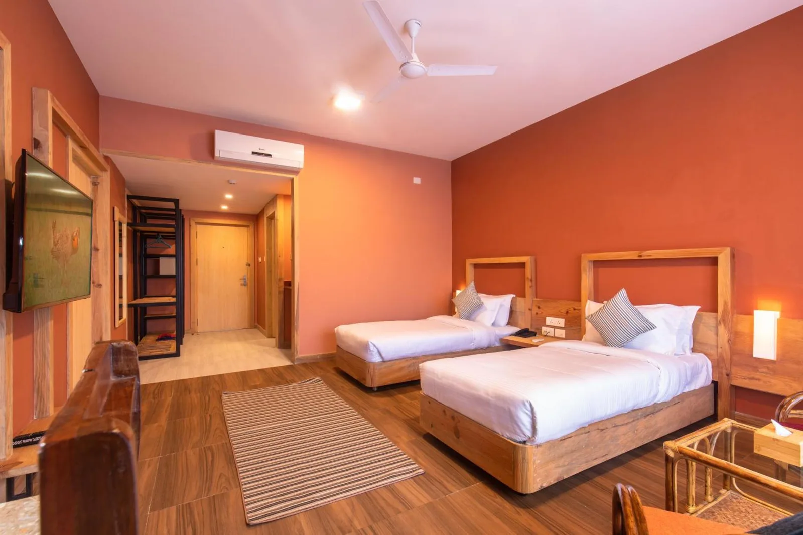 Twin bed guest room at Sunshine Resort Pokhara in Pokhara with warm décor, TV, and balcony window.