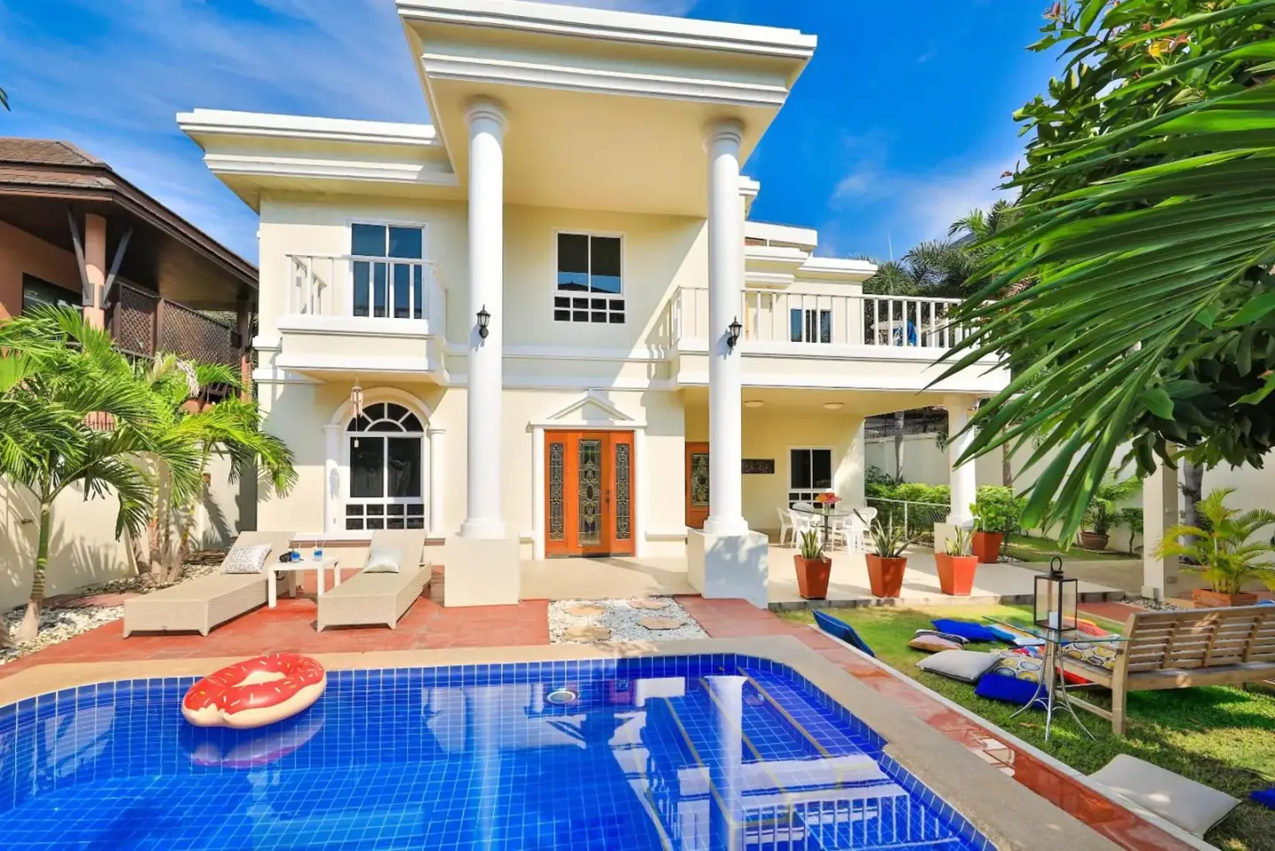 Vista exterior de Sweet Villas Pattaya mostrando la piscina y el jardín