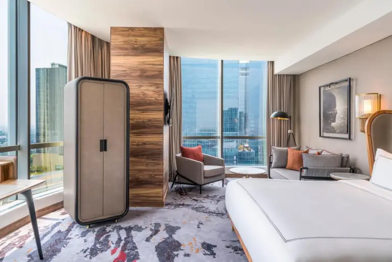 Swissôtel Jakarta PIK Avenue – Jakarta, Indonesia hotel – a bedroom with a large white bed and two tables at Swissôtel Jakarta PIK Avenue in Jakarta
