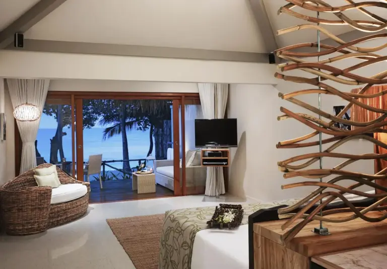 Interior elegante de una habitación en Taj Coral Reef Resort & Spa con vistas al océano