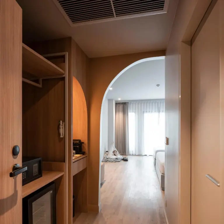 Flur im Hotelzimmer Terra Nara Pattaya mit Holzschränken, gewölbtem Durchgang und modernem Innendesign.