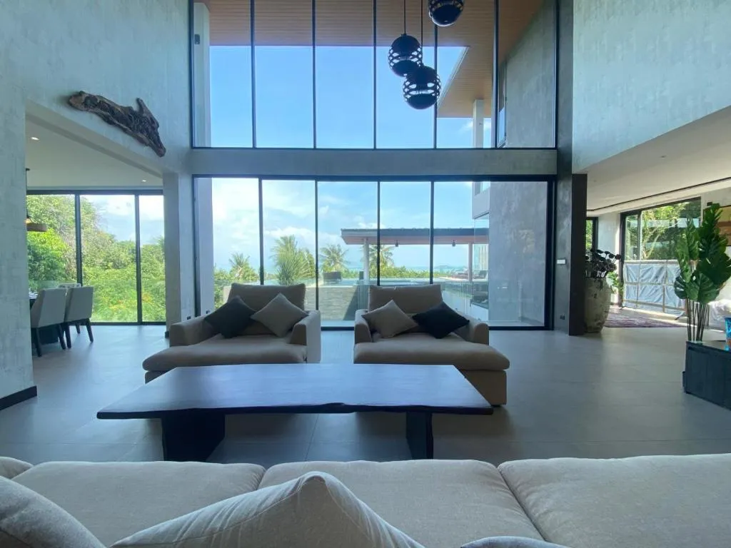 The Akbar Villa – Koh Samui, Thailand hotel – a bedroom with a bed with white sheets and a large window at The Akbar Villa in Bang Rak Beach