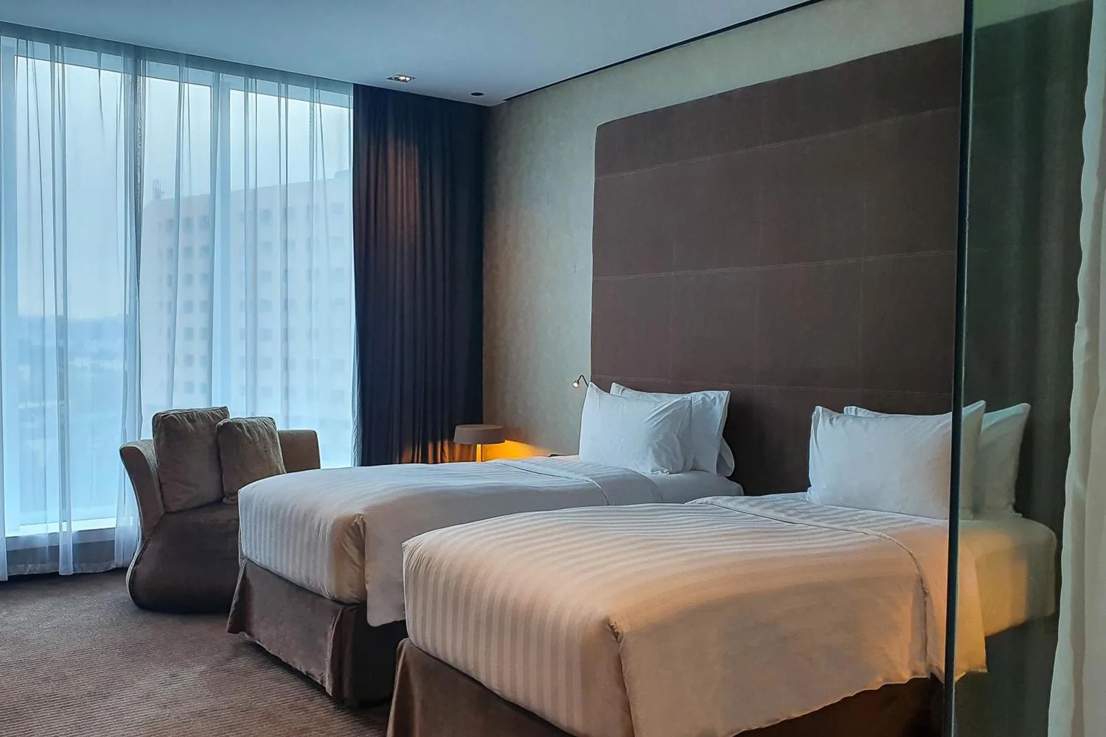 Twin room at The Canvas Dubai - MGallery Hotel Collection in Dubai with two single beds and city views.